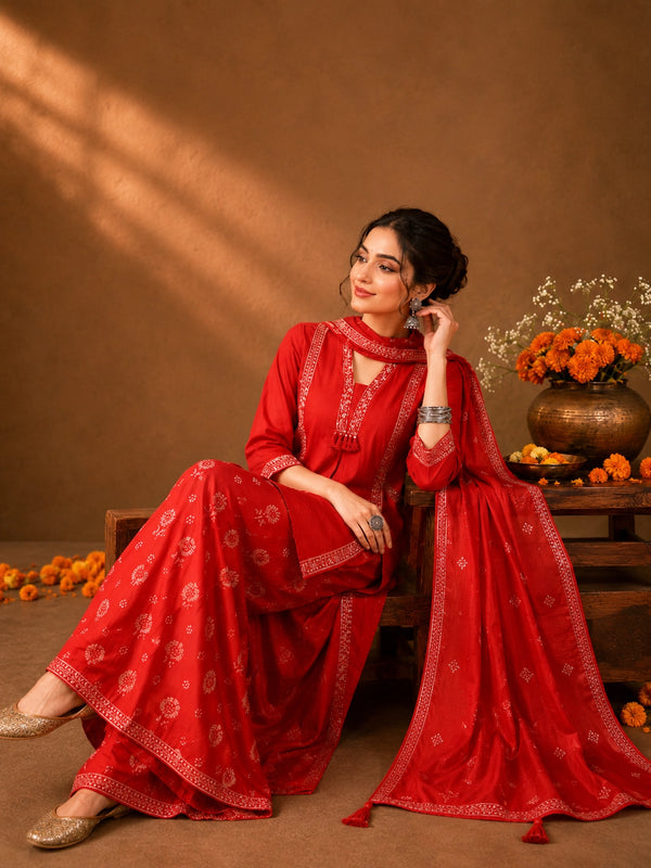 Woman in a Rani red printed Kurti Set with a dupatta, showcasing intricate patterns and elegant drape.