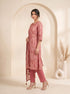 Woman wearing a rose pink printed kurti set with a dupatta, featuring leaf motifs and striped patterns.