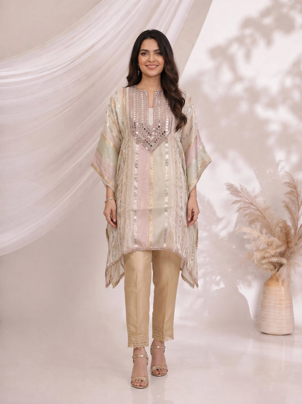 Woman wearing a beige striped kaftan top with mirror work neckline and matching pants, styled for an occasion.