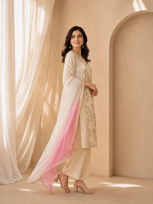 Woman wearing a cream floral print Kurti Set with a pink ombre dupatta and matching pants.