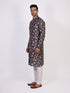 Man wearing a dark multi-color floral print kurta and white churidar pants, traditional ethnic wear.