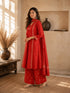 Woman wearing a rust-colored printed cotton kurti and pants set with intricate border details.