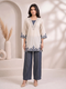 Woman wearing a beige embroidered V-neck kurta with dark blue palazzo pants, styled for a casual occasion.