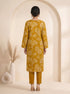 Woman wearing a mustard yellow floral print cotton kurti set with a dupatta and beige heels.
