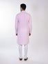 Man wearing a pink chikankari kurta with white churidar pants and brown embellished juttis.