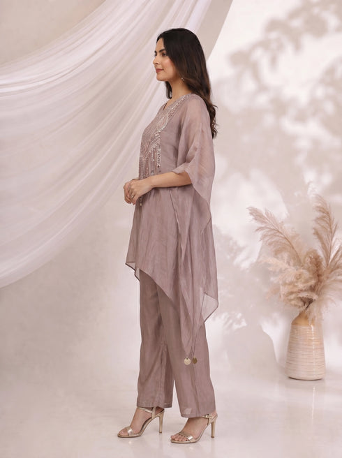 Woman wearing an onion-colored kaftan top with sequin embellishments and matching pants, styled for a festive occasion.