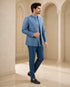 A woman wearing an elegant teal Indowestern outfit, showcasing intricate details and a flattering silhouette.