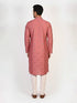 Man wearing a rose embroidered Kurta Pajama with white pants and brown jutti shoes.