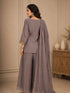 Woman wearing a pink embroidered choker neck Sharara with floral details on sleeves and hem.