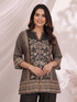 Woman wearing a black printed kurta with wide-leg pants, featuring floral motifs and a contrasting border.