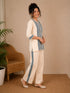 Woman wearing a cream kurta with blue paisley print, showcasing intricate embroidery and a band collar neckline.