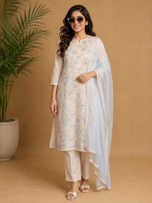 Woman wearing a blue floral print Kurti Set with a sheer blue dupatta, seated in a chair.