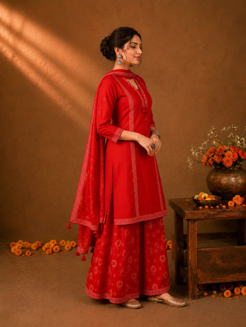 Woman in a Rani red printed Kurti Set with a dupatta, showcasing intricate patterns and elegant drape.