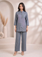Woman wearing a blue cotton co-ord set with embroidered details on the top and straight-leg pants.