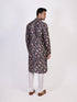 Man wearing a dark multi-color floral print kurta and white churidar pants, traditional ethnic wear.