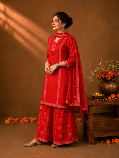 Woman in a Rani red printed Kurti Set with a dupatta, showcasing intricate patterns and elegant drape.