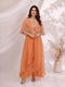Woman wearing an orange embellished cape and flowing pants set, perfect for festive occasions.