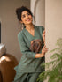 Woman wearing a Pista green co-ord set with a tree ring print top and textured pants.