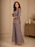 Woman wearing a pink embroidered choker neck Sharara with floral details on sleeves and hem.