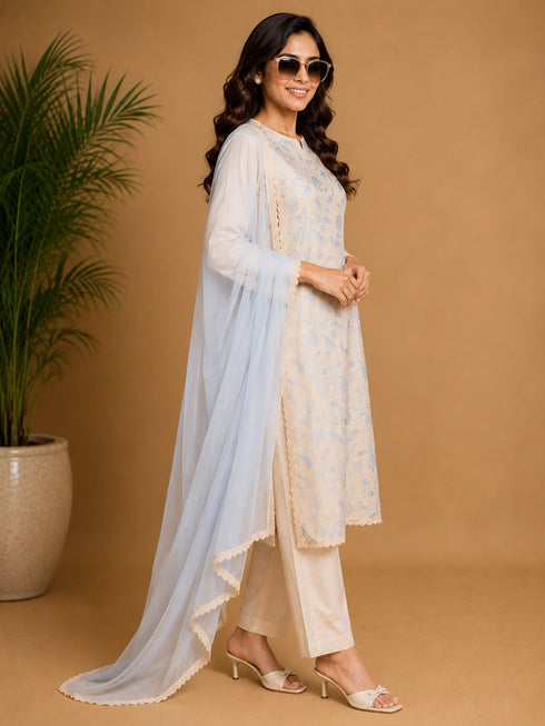 Woman wearing a blue floral print Kurti Set with a sheer blue dupatta, seated in a chair.