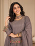 Woman wearing a pink embroidered choker neck Sharara with floral details on sleeves and hem.