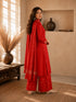 Woman wearing a rust-colored printed cotton kurti and pants set with intricate border details.