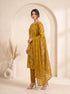 Woman wearing a mustard yellow floral print cotton kurti set with a dupatta and beige heels.