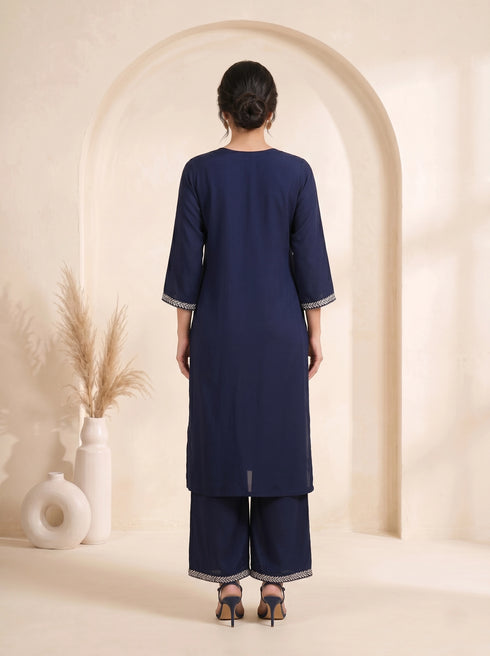 Navy blue embroidered kurti and pants set with a printed dupatta draped over the shoulder.