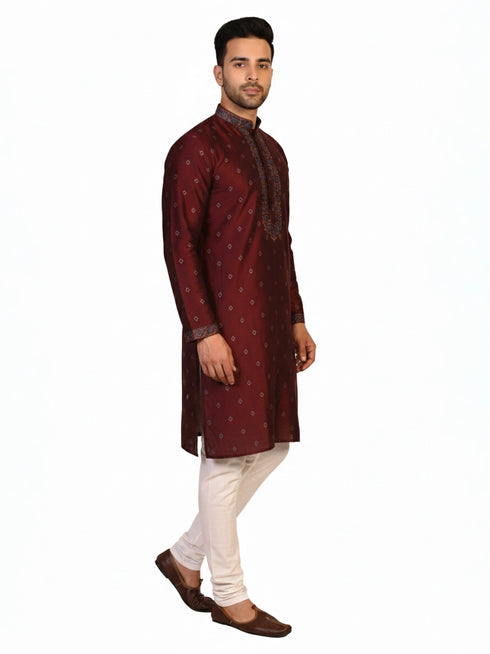 Man wearing a maroon kurta with a diamond pattern and embroidered neckline, paired with cream pants.