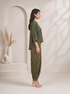 Woman wearing a green printed kurta with flowing sleeves and matching dhoti pants, styled with nude heels.