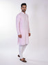 Man wearing a pink chikankari kurta with white churidar pants and brown embellished juttis.