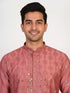 Man wearing a rose embroidered Kurta Pajama with white pants and brown jutti shoes.