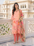 Woman wearing a pink floral print kurta set with shimmering pink pants and silver jhumka earrings.