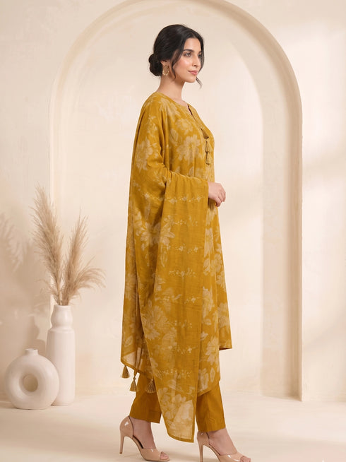 Woman wearing a mustard yellow floral print cotton kurti set with a dupatta and beige heels.