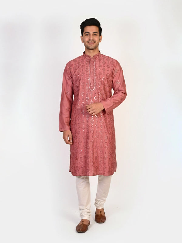 Man wearing a rose embroidered Kurta Pajama with white pants and brown jutti shoes.