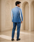 A woman wearing an elegant teal Indowestern outfit, showcasing intricate details and a flattering silhouette.