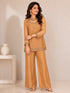 Woman wearing a mustard embroidered Sharara with intricate embellishments on the neckline and hem.