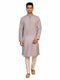 Man wearing a grey Kurta Pajama with a subtle geometric pattern and cream churidar pants.