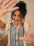 Woman wearing a cream kurta with blue paisley print, showcasing intricate embroidery and a band collar neckline.