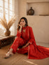 Woman wearing a rust-colored printed cotton kurti and pants set with intricate border details.