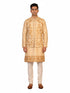 Man wearing a beige embroidered kurta jacket set with golden floral patterns, suitable for festive occasions.