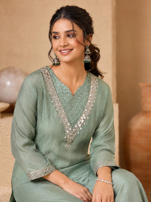 Woman wearing a green embroidered Sharara with silver embellishments on the neckline and cuffs.