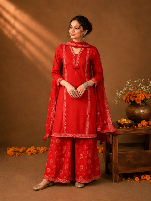 Woman in a Rani red printed Kurti Set with a dupatta, showcasing intricate patterns and elegant drape.