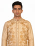 Man wearing a beige embroidered kurta jacket set with golden floral patterns, suitable for festive occasions.