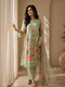 A woman models a green floral embroidered Kurti Set with matching pants and a dupatta, featuring delicate lace trim.