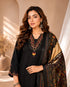 Woman wearing a black embroidered kurti and palazzo set with a colorful printed dupatta, seated on a chair.