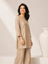 Woman wearing a shimmering grey embroidered kurta and matching pants, styled for a festive occasion.