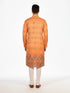 Man wearing an orange embroidered Kurta Pajama with cream pants and brown shoes, showcasing intricate patterns.