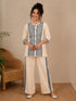 Woman wearing a cream kurta with blue paisley print, showcasing intricate embroidery and a band collar neckline.
