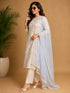 Woman wearing a blue floral print Kurti Set with a sheer blue dupatta, seated in a chair.